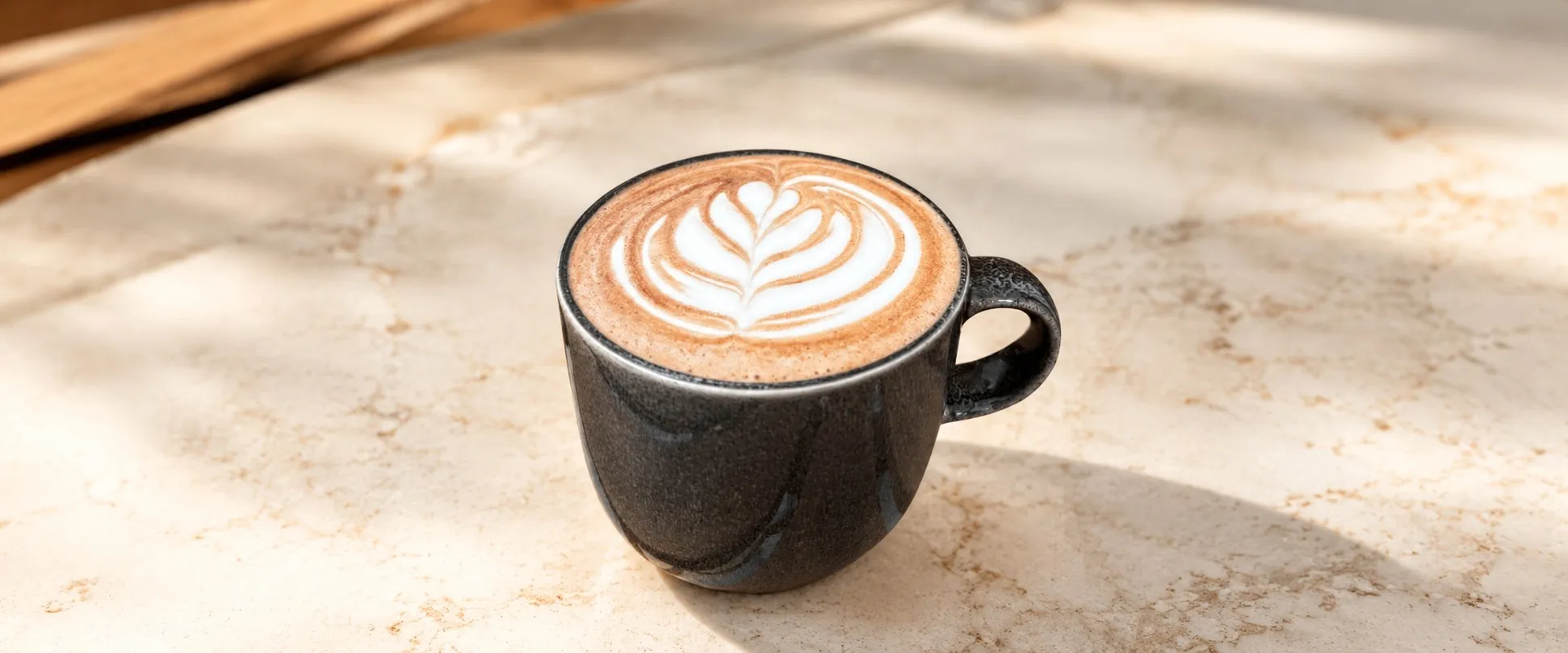 Cappuccino con arte en leche servido en taza negra